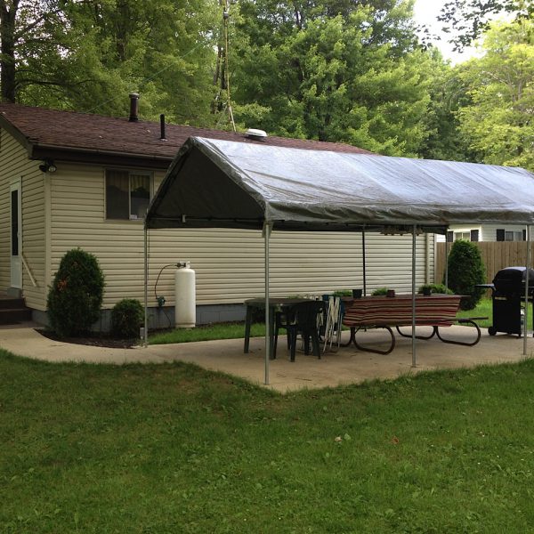 Rear view of cottage with canopy, picnic table, propane grill, and electric light for picnic and card playing at night!